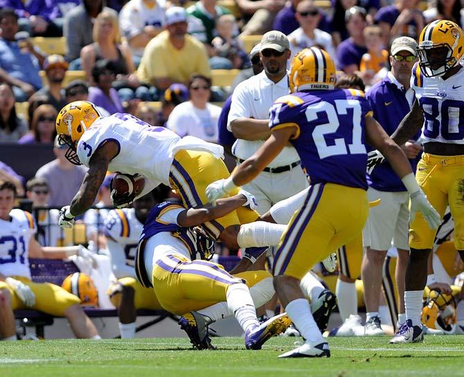 Freshman cornerback Kavahra Holmes (36) wraps his arms around junior wide receiver Odell Beckham Jr. (3) April 20, 2013 during the white squad's 37-0 victory against the purple squad in the National L Club Spring Game in Tiger Stadium.