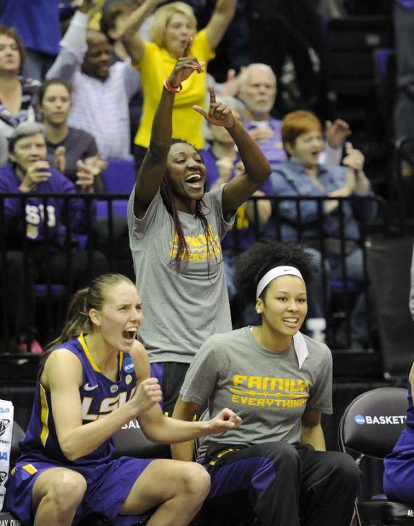 LSU freshman guard Raigyne Moncrief (standing, grey shirt), junior guard Akilah Bethel (sitting, grey shirt) and sophomore guard Anne Pedersen (4) celebrate on the bench Tuesday, March 25, 2014, during the Tigers' 76-67 win against West Virginia in the PMAC.