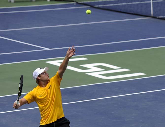 LSU sophomore Andrew Korinek begins his serve Sunday, March 30, 2014 during the Men's Tennis doubles match against Florida at W.T. "Dub" Robinson Stadium.