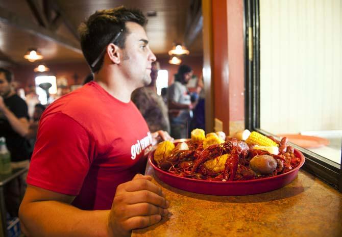 Hunter Thibodeaux prepares to deliver fresh boiled crawfish to guests Thursday, April 12, 2014 at LT's Seafood located in Broussard, La.