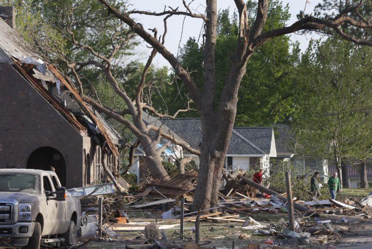 Residents view damage from a Sunday night tornado in Baxter Springs, Kan., Monday, April 28, 2014. The tornado left a trail of shattered homes, twisted metal and hanging power lines. One person died, but it was not clear whether the death was related to the storm. Volunteers were meeting early Monday to discuss cleanup efforts. Emergency officials say 60 to 70 homes and 20 to 25 businesses were destroyed or damaged in the town. (AP Photo/Orlin Wagner)