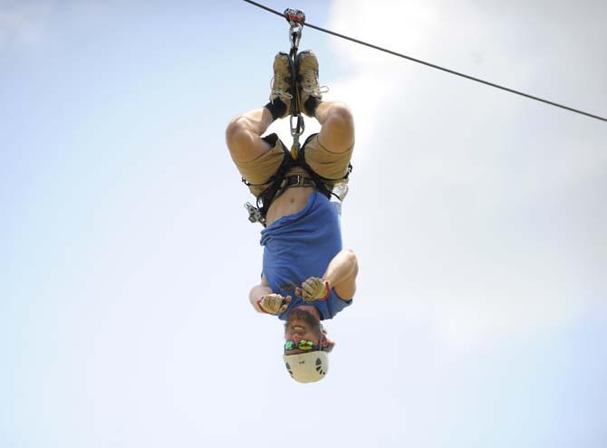 Tiki Zipline manager Daniel Truxillo hangs from the zipline Monday, April 21, 2014 in Denham Springs.