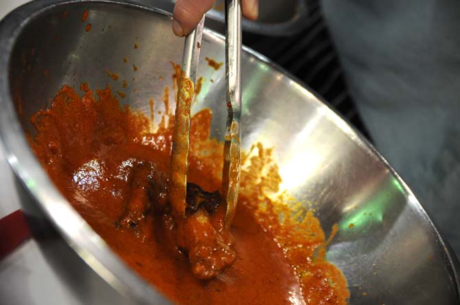 Wings are doused in sauce Saturday, April 26, 2014 during the first annual Louisiana Wing-a-thon at the Baton Rouge River Center.