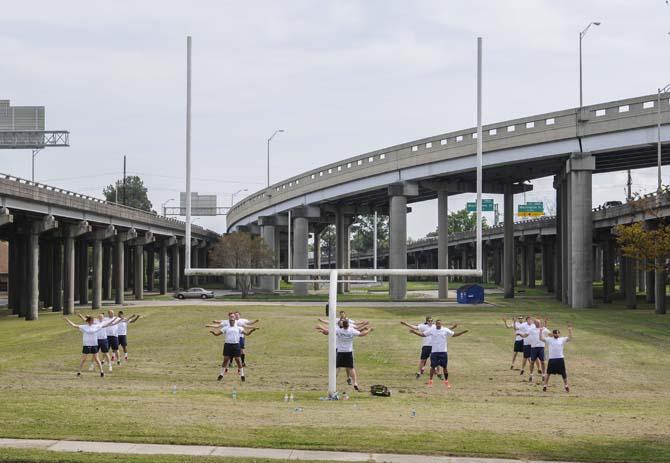 A group exercises Wednesday, April 2, 2014, on a football field between interstate ramps in Old South Baton Rouge.