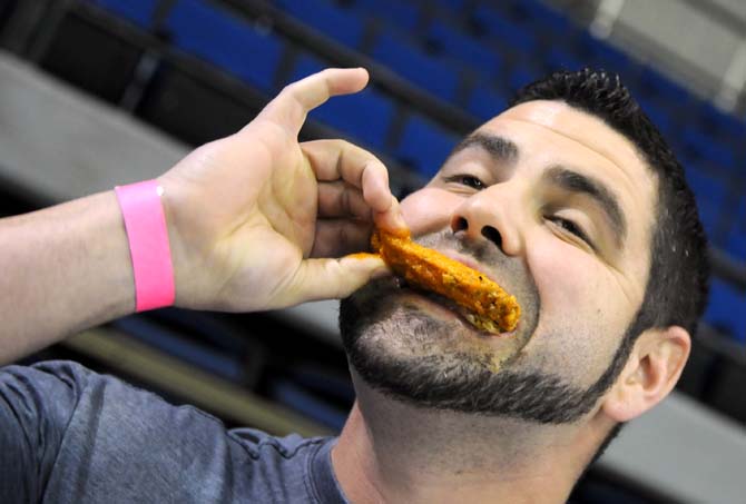 Contestant Brandon Grotsma bites into a wing with his pinky out during a hot wing eating contest Saturday, April 26, 2014 during the first annual Louisiana Wing-a-thon at the Baton Rouge River Center.