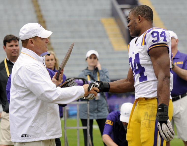 LSU junior defensive end Danielle Hunter (94) receives an award from coach Les Miles on Saturday, April 5, 2014 after the white squad's 42-14 victory against the purple squad in the National L Club Spring Game in Tiger Stadium.