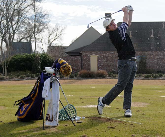 Junior golfer Myles Lewis practices his swing Monday, Jan. 20, 2014 at the University Club golf course.