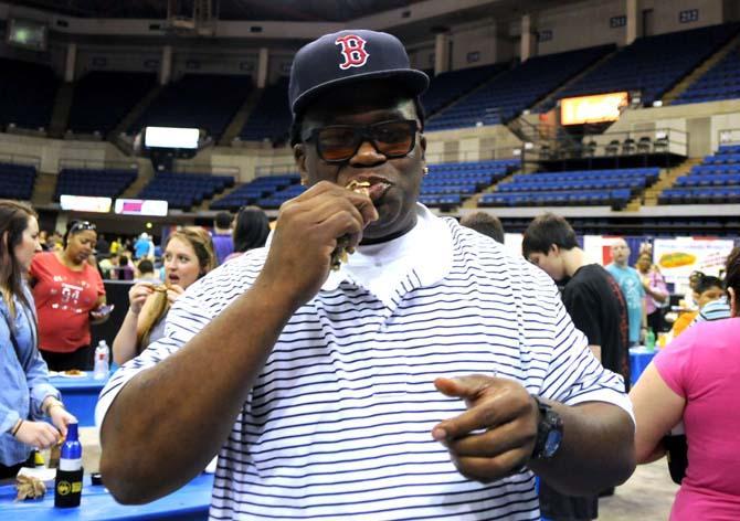 An attendee bites into a wing Saturday, April 26, 2014 during the first annual Louisiana Wing-a-thon at the Baton Rouge River Center.