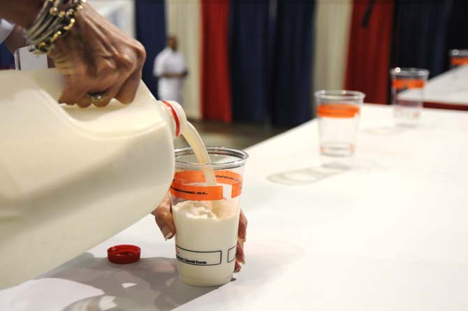 An event worker pours cold milk before the hot wing eating contest Saturday, April 26, 2014 during the first annual Louisiana Wing-a-thon at the Baton Rouge River Center.