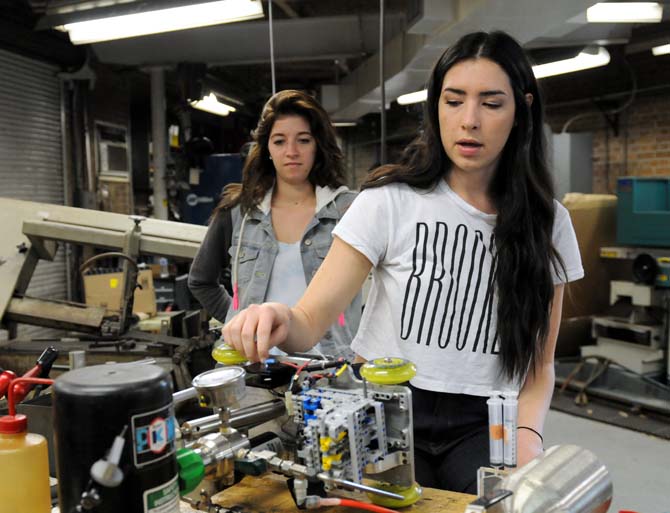 Chemical engineering junior Staci Duhon (left) and senior Aubyn Chavez explain the car Monday, March 31, 2014 at the machine shop in the Chemical Engineering Building.