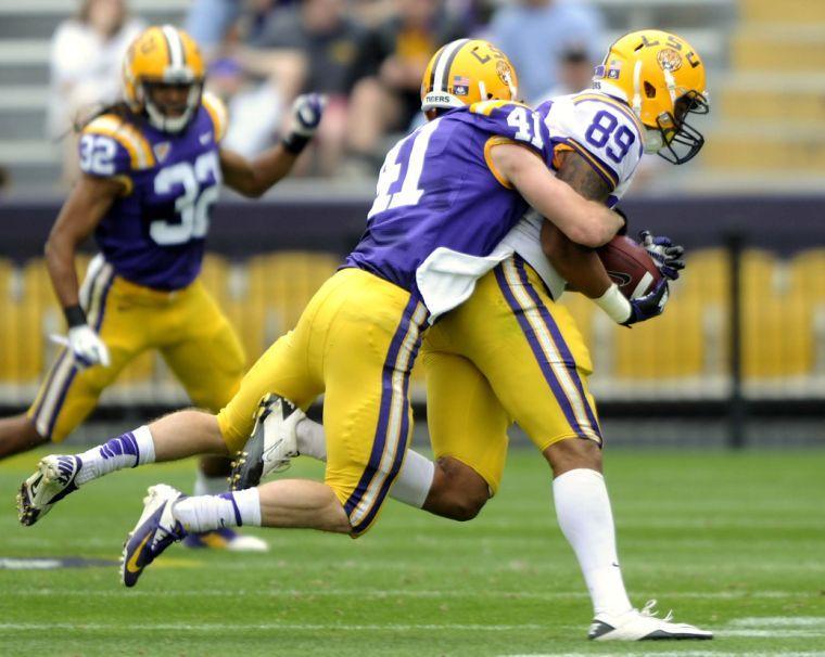 LSU junior safety Tommy LeBeau (41) tackles LSU sophomore tight end Desean Smith (89) on Saturday, April 5, 2014 during the white squad's 42-14 victory against the purple squad in the National L Club Spring Game in Tiger Stadium.