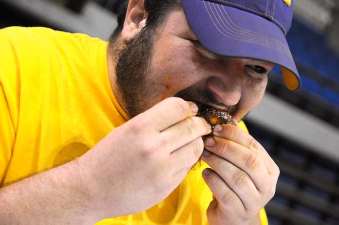 Agricultural education junior Adam Thibodeaux bites into a wing during a hot wing eating contest Saturday, April 26, 2014 during the first annual Louisiana Wing-a-thon at the Baton Rouge River Center.