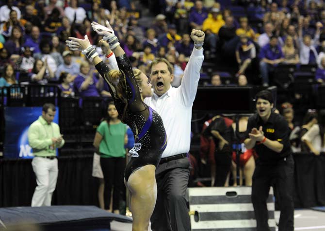 LSU gymnastics associate head coach Jay Clark celebrates after senior all-around Kaleigh Dickson's bar routine Saturday, April 5, 2014, during an NCAA Gymnastics Regional in the PMAC.