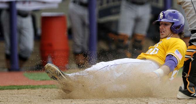 LSU junior infielder Conner Hale (20) slides into home plate to score a run Sunday, April 27, 2014, during the Tigers' 9-4 victory against Tennessee in Alex Box Stadium.