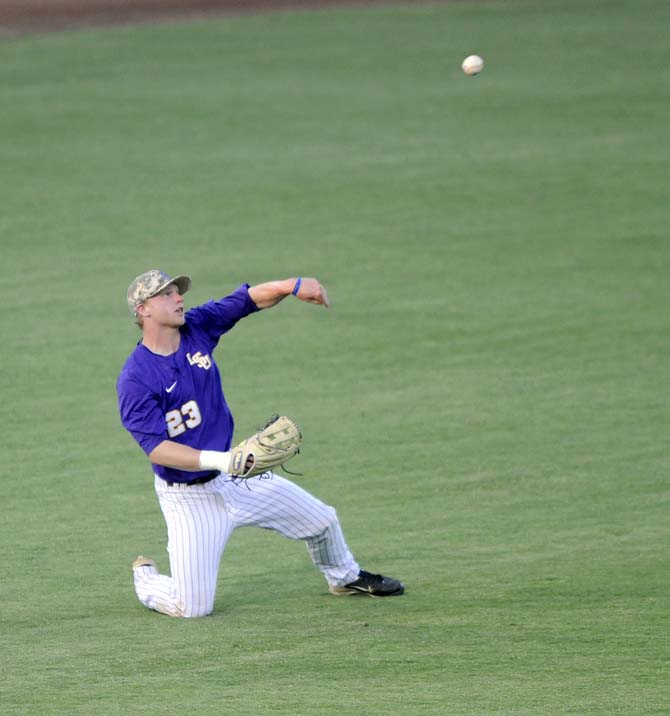 LSU freshman outfielder Jake Fraley (23) hurls the ball after his diving grab Tuesday, April 22, 2014, during the Tigers' 6-0 win against Tulane in Alex Box Stadium.