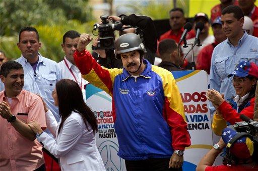 FILE - In this Feb. 24, 2014, file photo, a helmet wearing Venezuelan President Nicolas Maduro cheers motorcyclists during a rally in support of his government in Caracas, Venezuela. Since Feb. 12, opponents of President Nicolas Maduro have been staging countrywide protests that the government says have resulted in scores of deaths and more than more than a hundred injured. The demonstrators blame Maduro's administration for the country's high crime rate and economic troubles. (AP Photo/Rodrigo Abd)