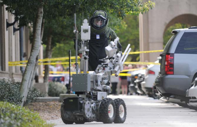 A robot and a bomb specialist from the Baton Rouge City Police Bomb Squad are sent out to examine the suspicious packages Monday, April 7, 2014 near Thomas D. Boyd Hall.