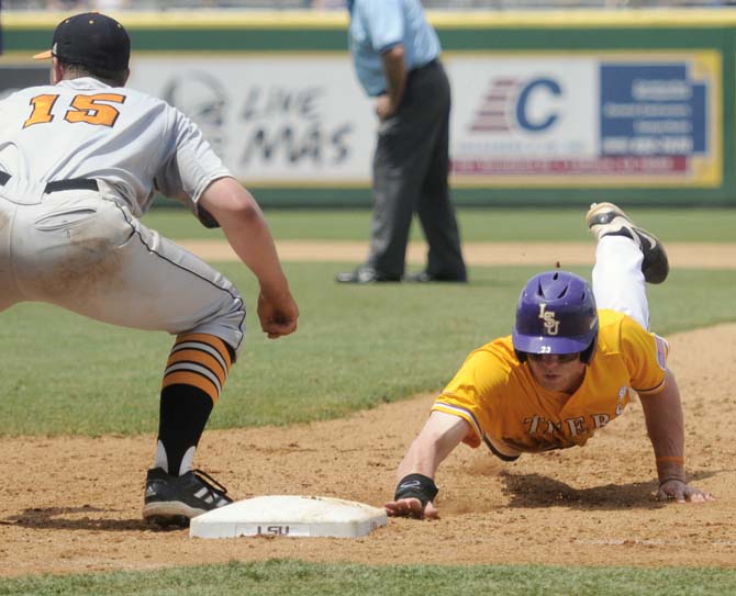 LSU freshman outfielder Jake Fraley (23) slides into first base Sunday, April 27, 2014, during the Tigers' 9-4 victory against Tennessee in Alex Box Stadium.