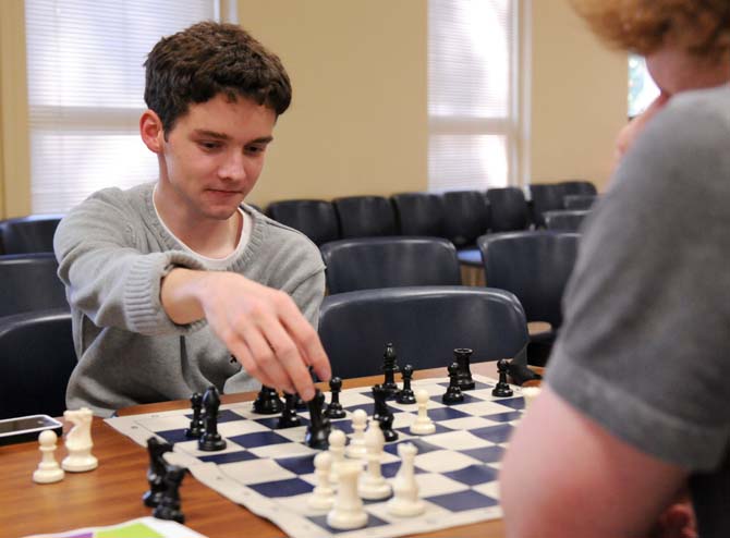 Chemical engineering sophomore Connor Lunney moves the queen piece Tuesday, April 22, 2014 during chess practice in Peabody Hall.