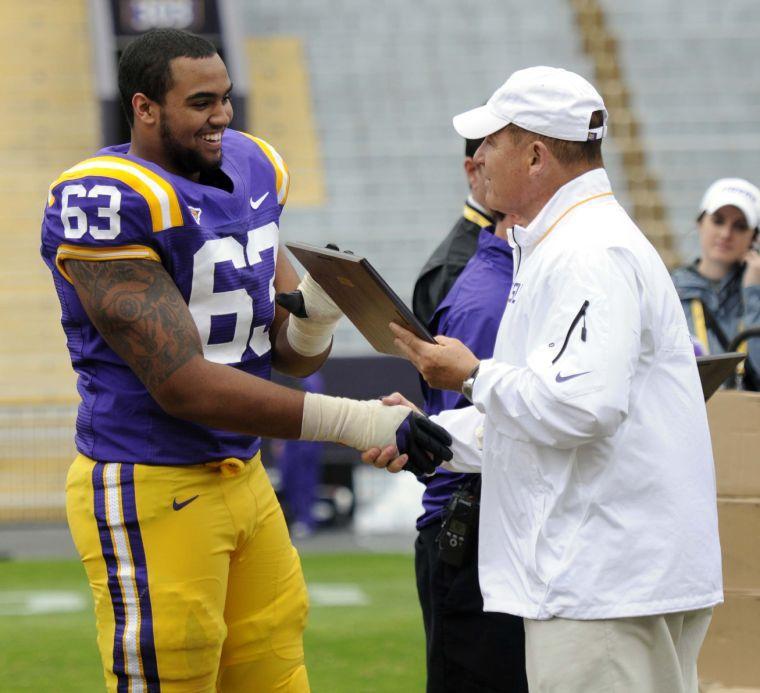 LSU freshman offensive lineman K.J. Malone (63) accepts an award from Les Miles on Saturday, April 5, 2014 after the white squad's 42-14 victory against the purple squad in the National L Club Spring Game in Tiger Stadium.