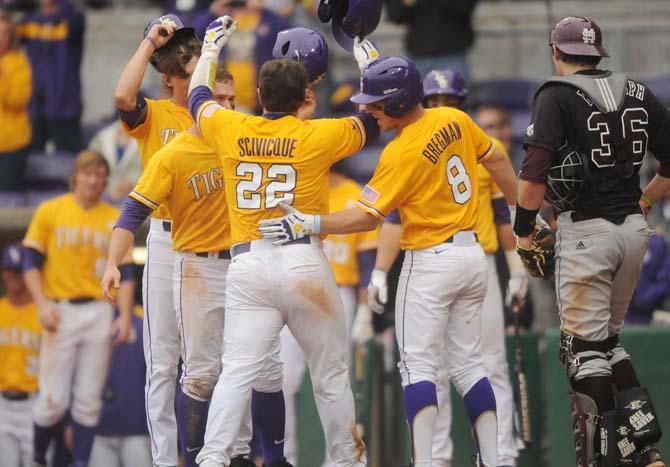 LSU junior catcher Kade Scivicque (22) is celebrated at home-plate after a grand-slam Sunday, April 6, 2014 during the Tigers' 17-4 victory against Mississippi State at Alex Box Stadium.