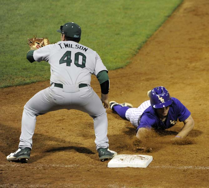 LSU sophomore infielder Alex Bregman (8) slides into first base Tuesday, April 22, 2014, during the Tigers' 6-0 win against Tulane in Alex Box Stadium.