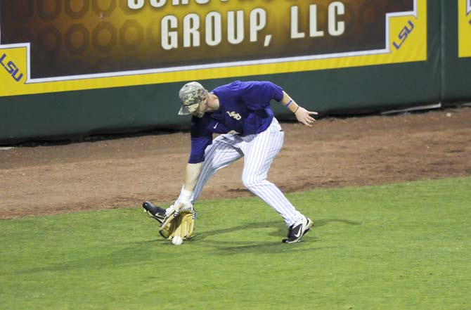 LSU freshman outfielder Jake Fraley (23) snags the ball Tuesday, April 22, 2014, during the Tigers' 6-0 win against Tulane in Alex Box Stadium.