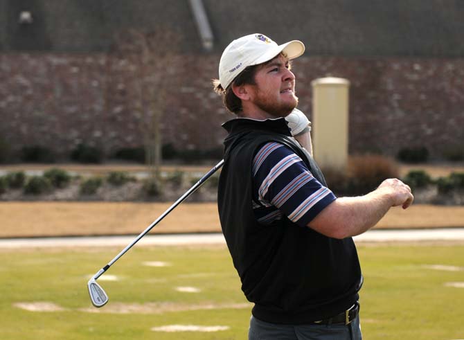 Junior golfer Myles Lewis practices his swing Monday, Jan. 20, 2014 at the University Club golf course.