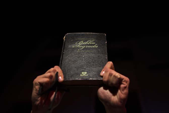 A man holds up a Bible during a reenactment of the Passion of Jesus Christ on Good Friday during Holy Week celebrations in the Rocinha slum of Rio de Janeiro, Brazil, Friday, April 18, 2014. Holy Week commemorates the last week of the earthly life of Jesus Christ culminating in his crucifixion on Good Friday and his resurrection on Easter Sunday. (AP Photo/Hassan Ammar)