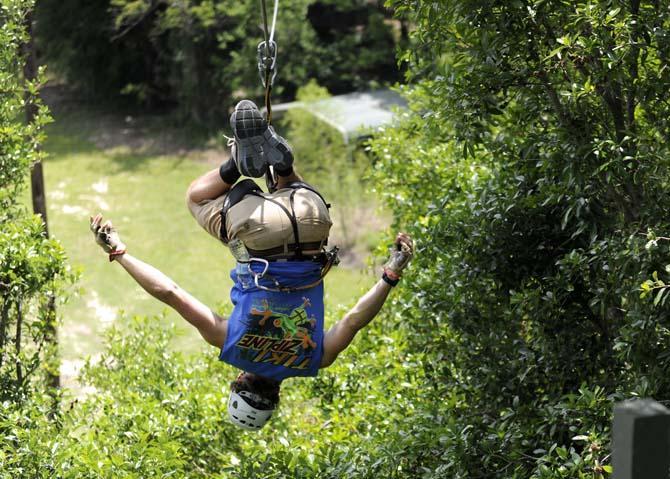 Tiki Zipline manager Daniel Truxillo hangs from the zipline Monday, April 21, 2014 in Denham Springs.