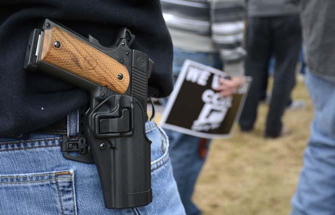 A man open carries a 1911 handgun while listening to Connecticut Citizens Defense League President Scott Wilson during a CCDL gun rights rally at the Connecticut state capitol in Hartford, Saturday April 5, 2014 against the state's gun control law passed one year ago on April 4, 2013 in response to the Newtown school shooting. (AP Photo/The Bristol Press, Mike Orazzi) MANDATORY CREDIT