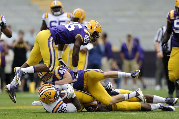 LSU junior safety Tommy LeBeau (41) and junior linebacker Deion Jones (45) tackle LSU junior tight end Dillon Gordon (85) on Saturday, April 5, 2014 during the white squad's 42-14 victory against the purple squad in the National L Club Spring Game in Tiger Stadium.