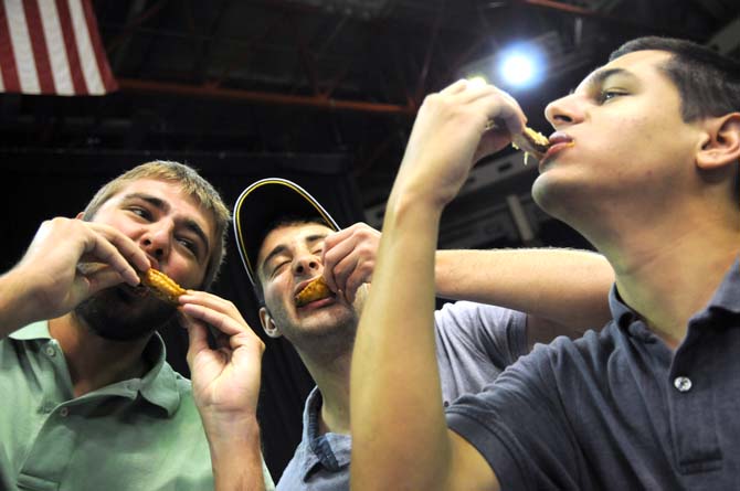 Petroleum engineering junior Travis Stevenson (left), finance senior Luke Reese (center) and petroleum engineering senior Max Carrier (right) all bite into wings Saturday, April 26, 2014 during the first annual Louisiana Wing-a-thon at the Baton Rouge River Center.