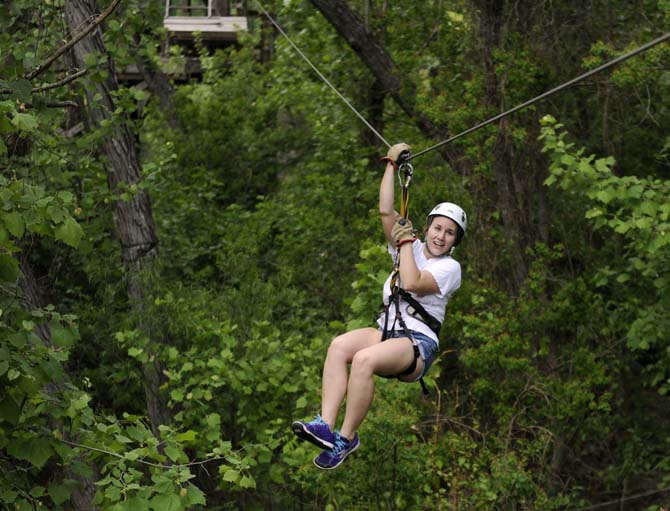 Education junior and zip guide Elaine Martin hangs from the zipline Monday, April 21, 2014 at Tiki Zipline in Denham Springs.