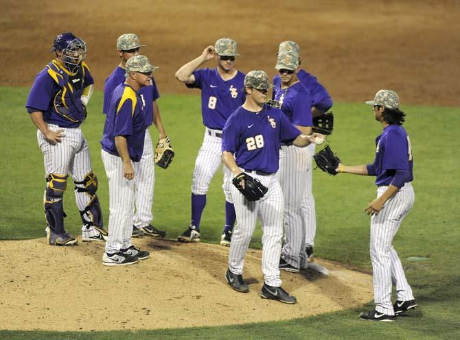 LSU junior pitcher Kyle Bouman (28) passes the ball to junior pitcher Zac Person (49) on Tuesday, April 22, 2014, during the Tigers' 6-0 win against Tulane in Alex Box Stadium.