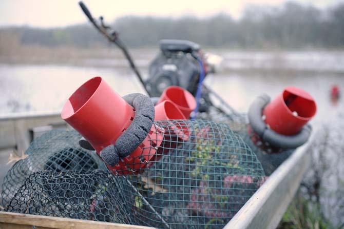 Crawfish traps are prepped for pond placement Thursday, March 6, 2014 in New Iberia, La.