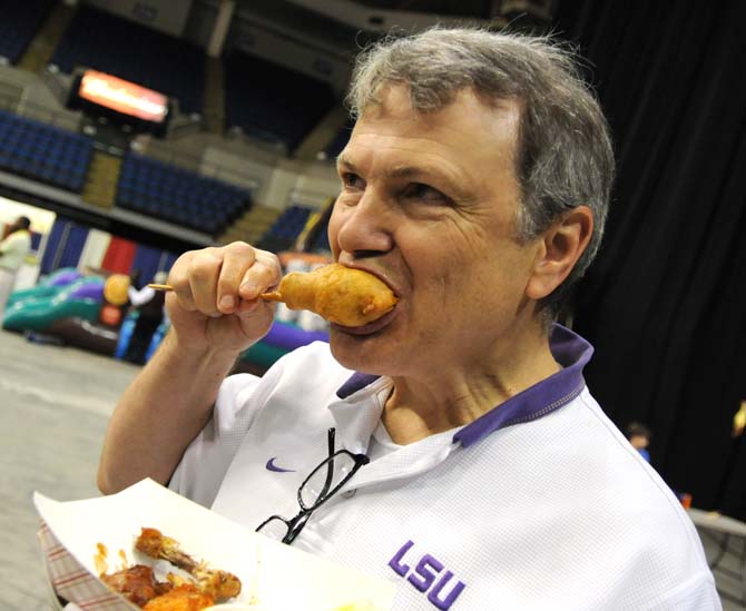 An attendee bites into a deep fried wing Saturday, April 26, 2014 during the first annual Louisiana Wing-a-thon at the Baton Rouge River Center.