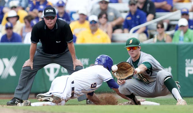 LSU sophomore outfielder Mark Laird (9) slides back to first base as a Southeastern first baseman catches the ball Friday, May 30, 2014 during the Tigers' 8-4 victory against the Lions in Alex Box Stadium.