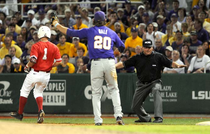 An umpire calls a Houston runner "safe" as LSU junior infielder Conner Hale (20) argues for the opposite call Saturday, May 31, 2014 during the Tigers' 5-1 victory against the Cougars in Alex Box Stadium.