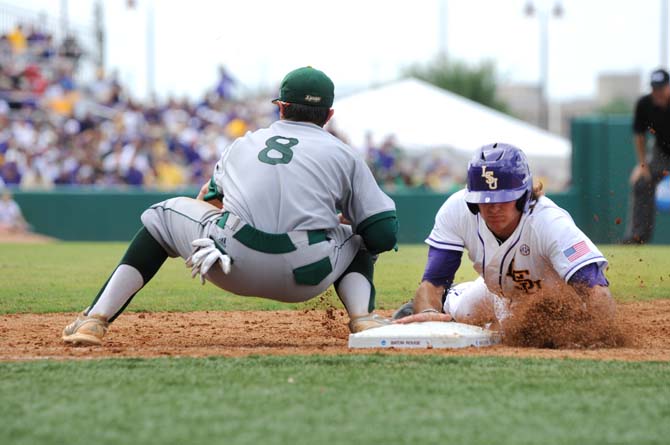 LSU sophomore outfielder Mark Laird (9) slides into first base to avoid being tagged out Friday, May 30, 2014 during the Tigers' 8-4 victory against Southeastern Louisiana in Alex Box Stadium.