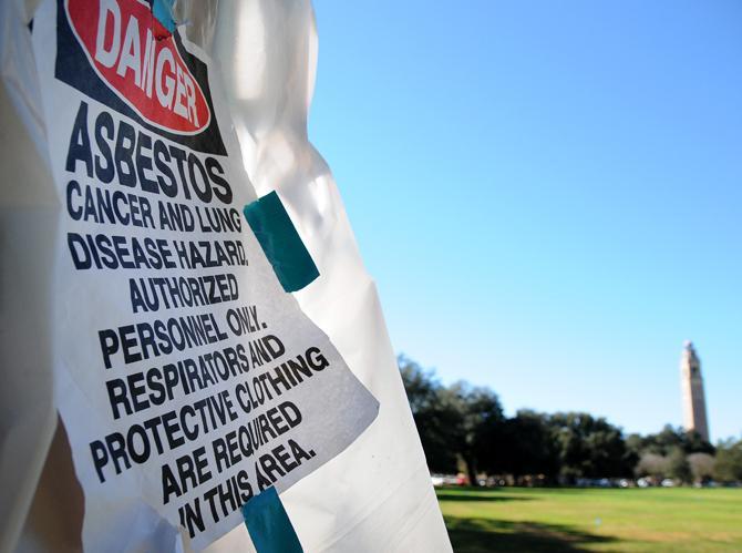 Signs on black tents warn of dangerous asbestos being removed from the tunnels underneath LSU's campus.