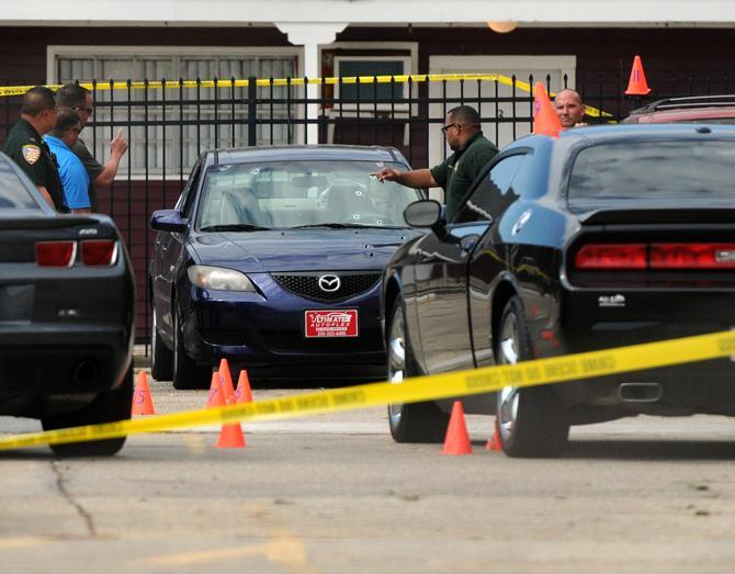 East Baton Rouge Sheriff's Office investigates bullet holes in a blue Mazda on Friday, May 2, 2014 in the parking lot of Gaslite IV apartments.