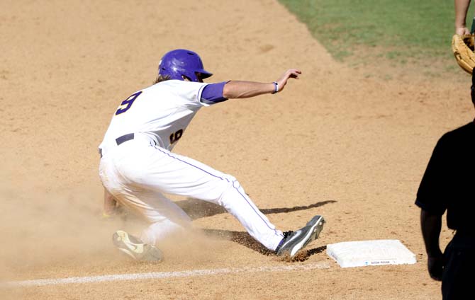 LSU sophomore outfielder Mark Laird (9) slides into first base Friday, May 30, 2014 during the Tigers' 8-4 victory against Southeastern Louisiana in Alex Box Stadium.