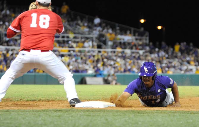 LSU senior infielder Christian Ibarra (14) slides back into first base Saturday, May 31, 2014 during the Tigers' 5-1 victory against Houston in Alex Box Stadium.