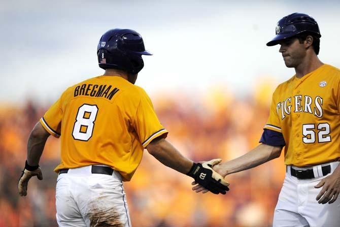 LSU sophomore infielder Alex Bregman (8) gives LSU volunteer assistant coach Will Davis (52) a high-five Sunday, April 1, 2014 during the Tigers' 5-4 loss against Houston in Alex Box Stadium.