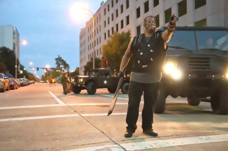 An actor attempts to intimidate race participants Saturday, June 28, 2014 during the post-apocalypse themed 5k race "Escape from Baton Rouge" near the Capitol building downtown.