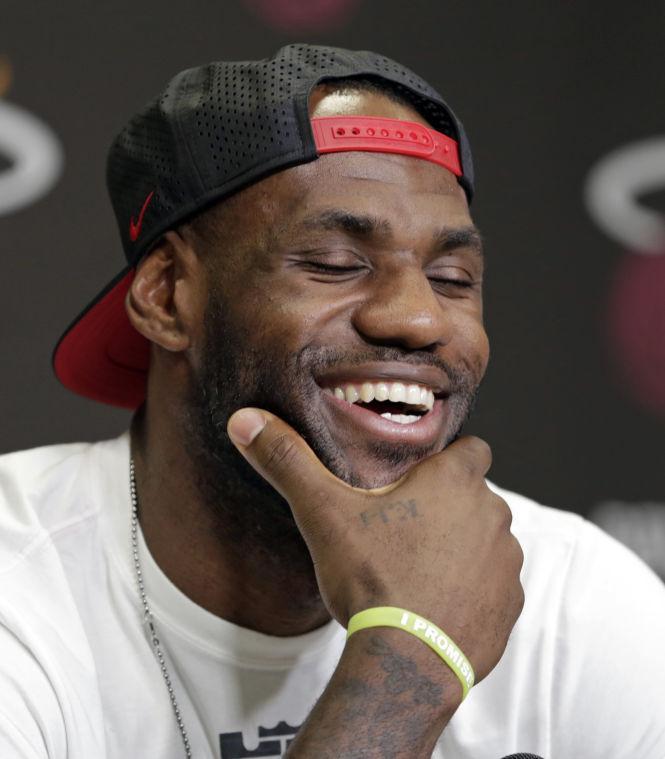 Miami Heat's LeBron James has a light moment during a news conference in Miami, Tuesday, June 17, 2014. James says he's going on vacation with his family before making any decisions about his future. The Miami Heat held their season-wrap up team meeting on Tuesday afternoon and one of the biggest questions is about the future of the roster. James could become a free agent in a couple of weeks and the four-time MVP says he still has not thought about his plans.(AP Photo/Alan Diaz)