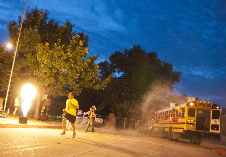 Race participants run past several obstacles Saturday, June 28, 2014 during the post-apocalypse themed 5k race "Escape from Baton Rouge" near the Capitol building downtown.