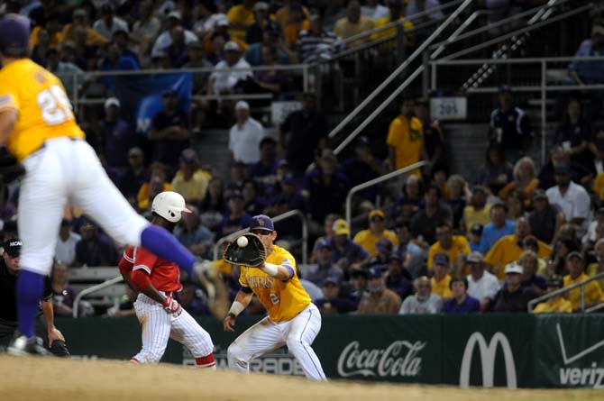 LSU junior infielder Tyler Moore (2) reaches out to catch the ball thrown by junior pitcher Kyle Bouman Monday, April 2, 2014 during the Tigers' 12-2 loss against Houston in Alex Box Stadium.