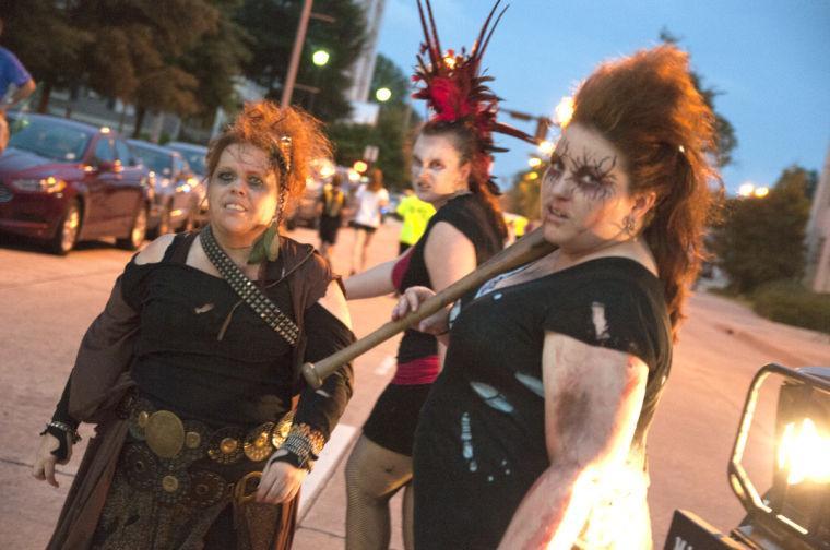 Actors attempt to intimidate race participants Saturday, June 28, 2014 during the post-apocalypse themed 5k race "Escape from Baton Rouge" near the Capitol building downtown.